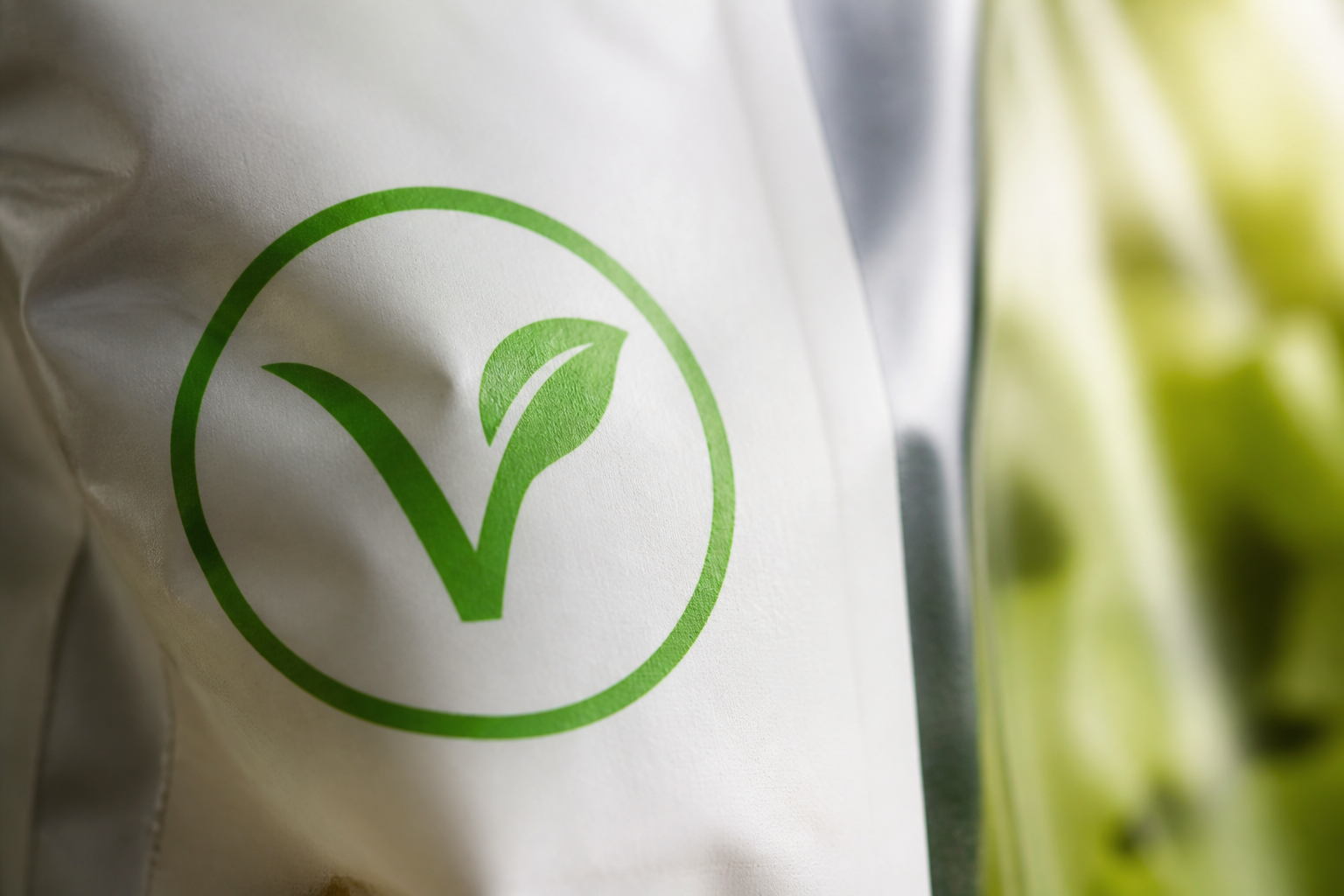 Macro photograph of a vegan certification symbol on a product package, clean design, shallow depth of field, professional studio lighting.